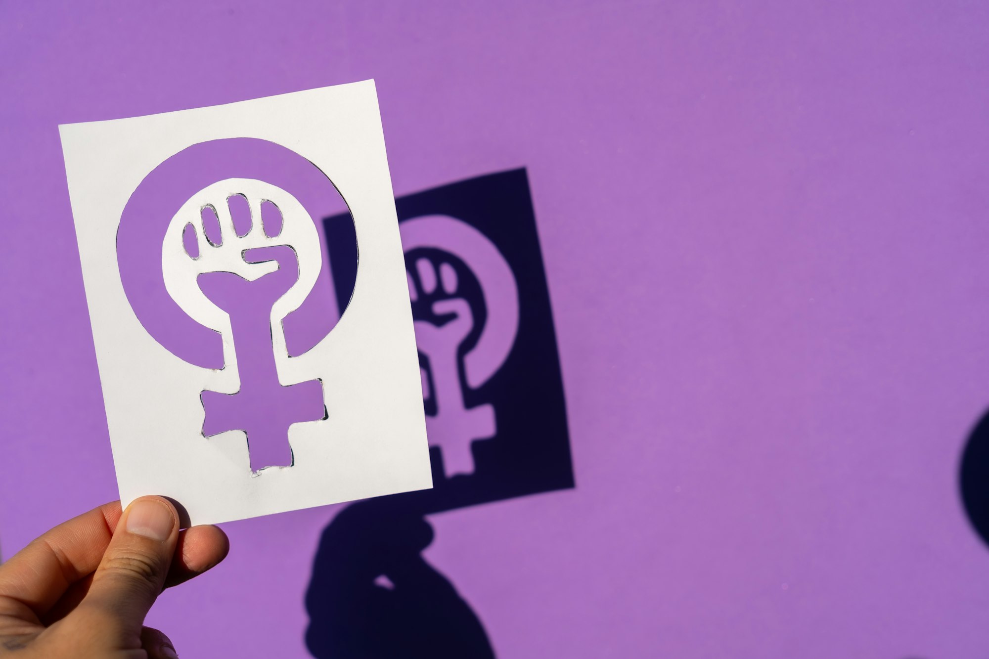 Symbol of the struggle of feminism on a purple background