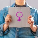 Woman holding cardboard sign with female symbol. Feminist concept, feminism, feminist activist